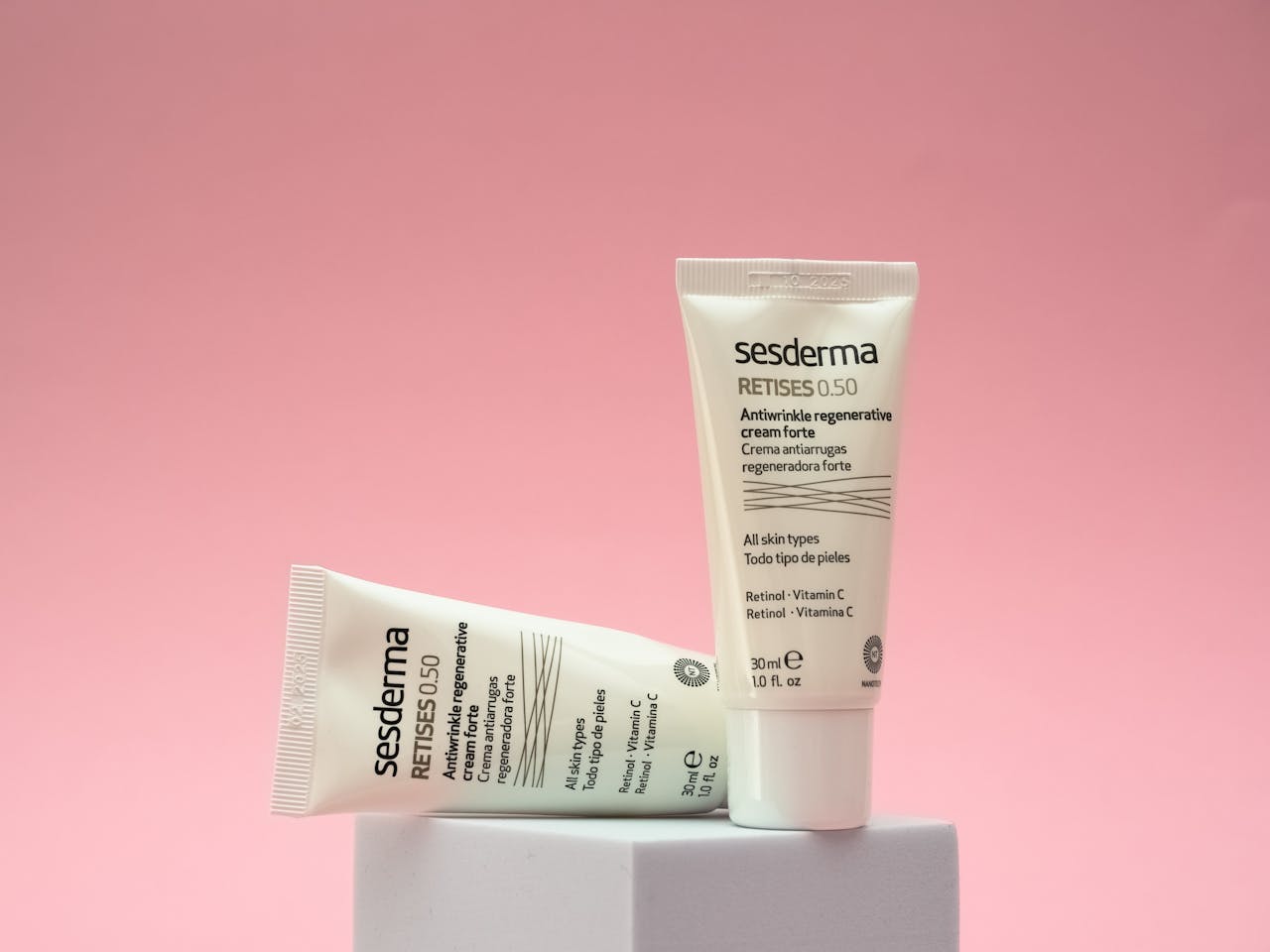 about-img Two Sesderma Retises 0.50 skincare tubes displayed on a pink background, highlighting anti-aging cream.