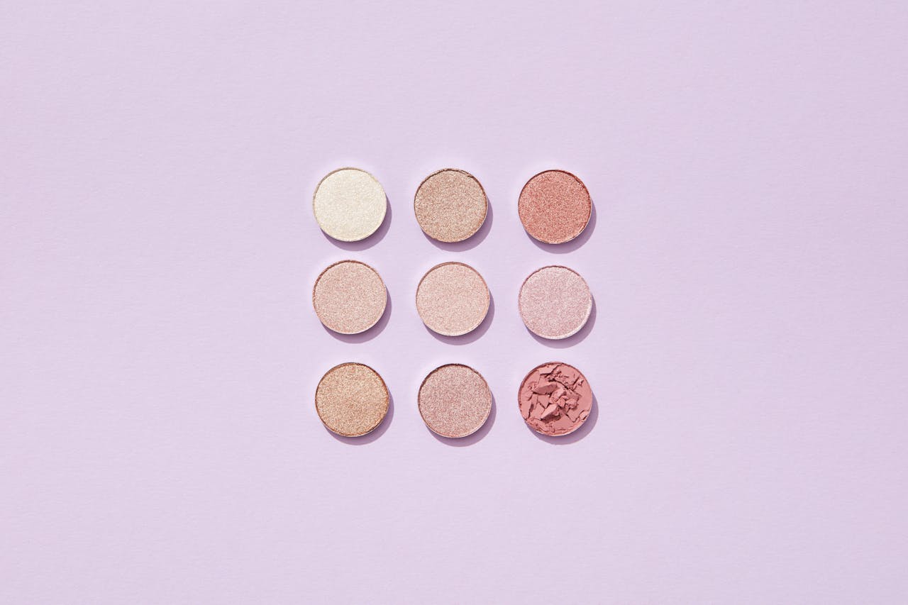 portfolio-img-05 Flat lay of pastel makeup powders arranged in a grid on a light surface.