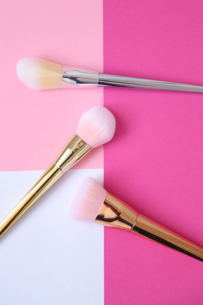 our-services-06 Stylish makeup brush set on pink and white geometric background, perfect for beauty enthusiasts.